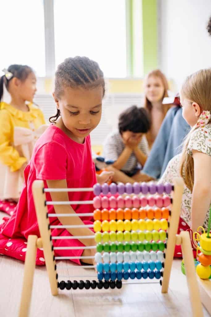 Girl In Red Dress Playing With An Abacus